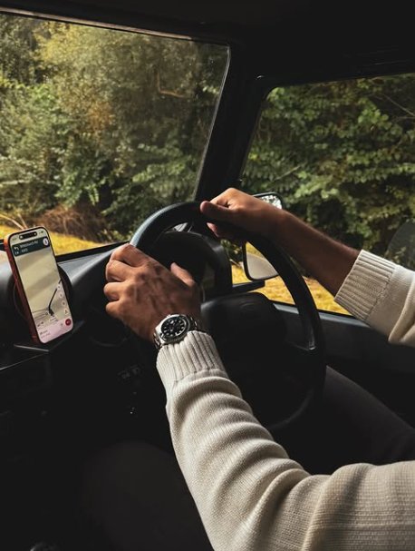 View from inside a vehicle travelling along a wooded road
