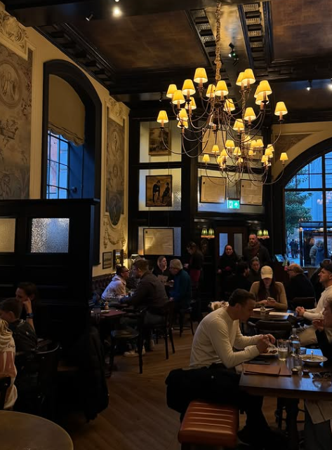 Guests seated beneath a chandelier in a pub